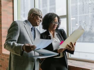 A Man and Woman Having Conversation while Standing Near the Window Matt/Dull Finish Presentation Folders