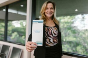 woman holding a Cadti printed business flyer for conference -Catdi Houston printing solutions