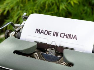 Image of old printer with paper spelling "made in China" Catdi Houston printing shop