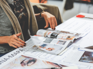 woman reviewing printing collateral on table at Houston central office - Catdi Houston printing packages